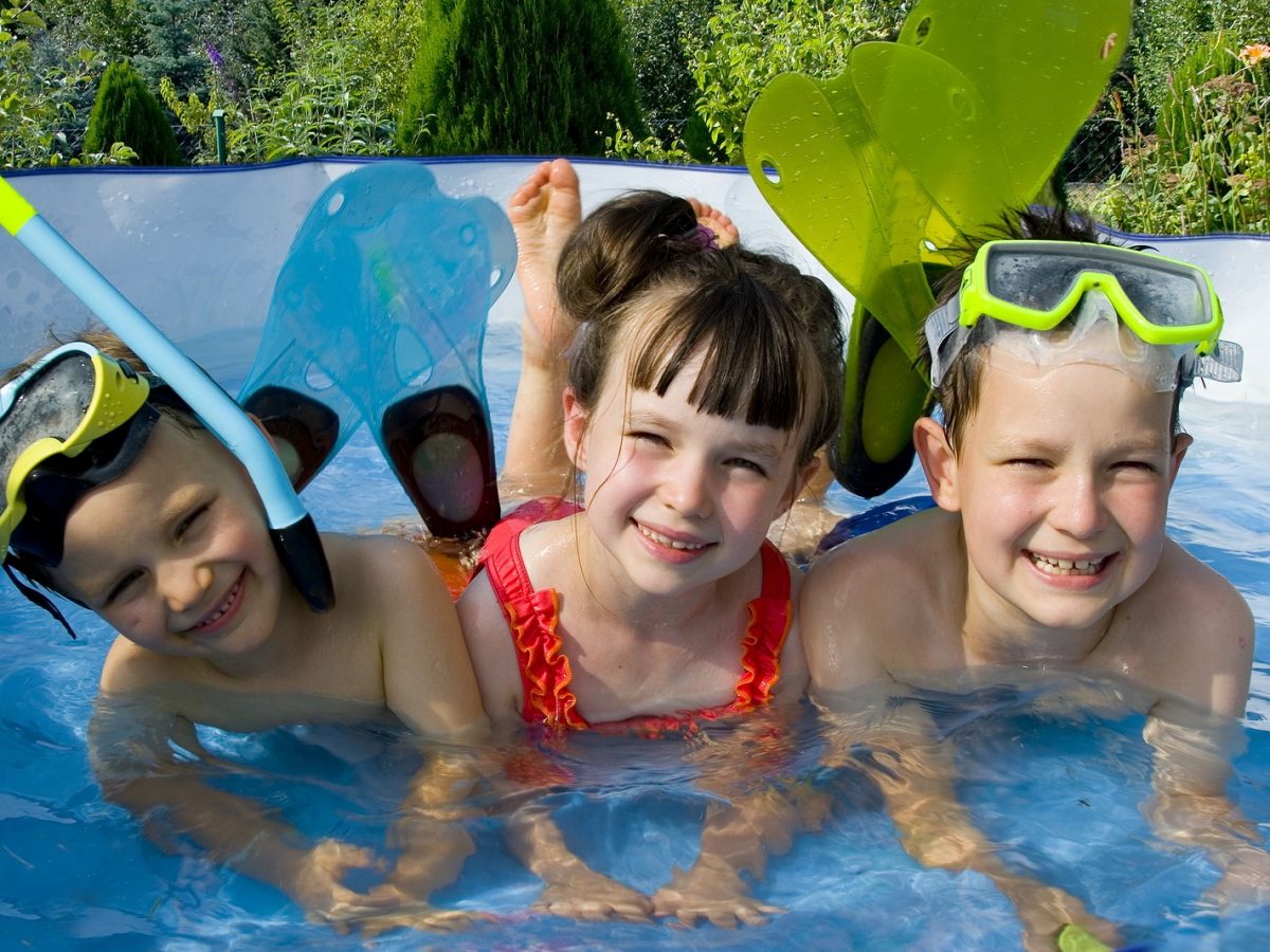 Дети плавают в бассейне в лагере